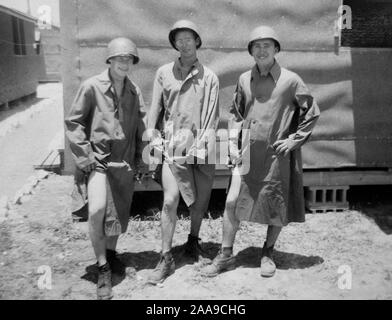 Trois marins sur Guam joyeusement montrer leurs jambes pour un drôle de portrait, ca. 1944. Banque D'Images