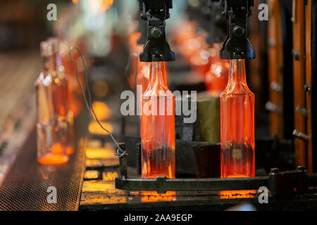 Glassworks. L'industrie du verre. Le procédé de fabrication de bouteilles en verre en fusion.les contenants de verre chaud sur la courroie du convoyeur Banque D'Images