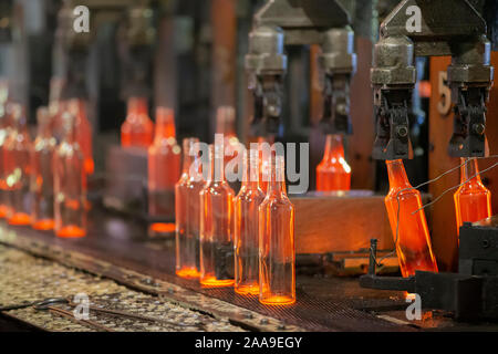 Glassworks. L'industrie du verre. Le procédé de fabrication de bouteilles en verre en fusion.les contenants de verre chaud sur la courroie du convoyeur Banque D'Images