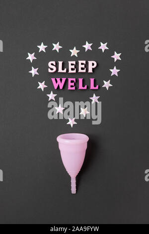 Coupe menstruelle rose sur fond noir avec avec cœur et mots bien dormir. Possibilité d'utilisation concept tasse la nuit, zéro déchet, l'épargne, le minimalisme. Banque D'Images