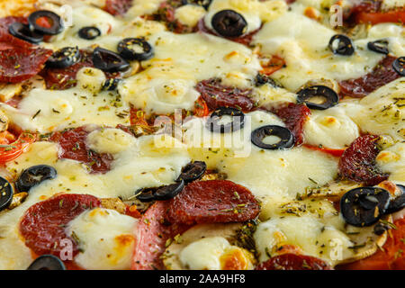 Fond de pizza. Pizza à la saucisse et d'autres ingrédients close up close up. Banque D'Images