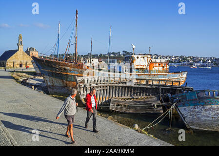 Les touristes visitant les épaves de bateaux de pêche de chalutiers en bois / bateaux dans le port - port de Camaret-sur-Mer, Finistère, Bretagne, France Banque D'Images