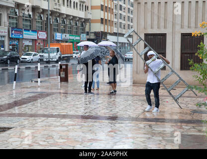 Malgré les fortes pluies les visiteurs et les touristes errent encore tour à Dubaï qui est généralement réputé pour son ensoleillement Banque D'Images