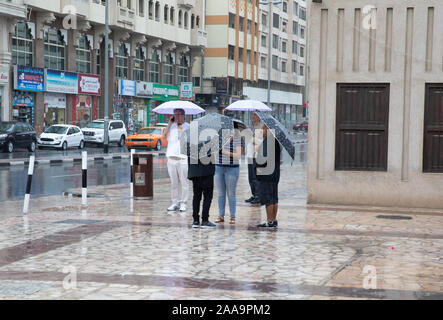 Malgré les fortes pluies les visiteurs et les touristes errent encore tour à Dubaï qui est généralement réputé pour son ensoleillement Banque D'Images