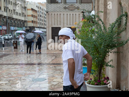 Malgré les fortes pluies les visiteurs et les touristes errent encore tour à Dubaï qui est généralement réputé pour son ensoleillement Banque D'Images