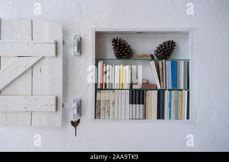 Gros plan d'une petite étagère en bois miteux avec obturateur blanc et décoration Banque D'Images