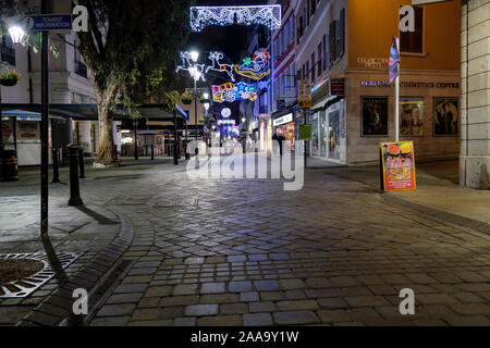 Main Street, Gibraltar, dans la soirée avant Noël après que les magasins ont fermé mais des décorations illuminées Banque D'Images