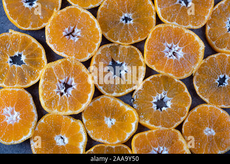 Morceaux ronds de la mandarine sur fond sombre. la texture de mandarine Banque D'Images