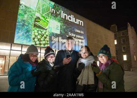 Sujlesh Sharma, Skye Zalenski, Evelina Venckute Deidrah et Carrillo, étudiants de troisième cycle à l'école de chimie à l'université d'Édimbourg posent avec leur téléphone mobile dans de d'un affichage à l'Bristo Square, Édimbourg, montrant le tableau périodique en vie à venir à l'appui de la Semaine de la chimie. Banque D'Images