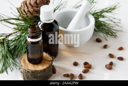 Cosmétiques naturels, produits eco, la composition des bouteilles en verre avec de l'huile de cèdre, noix de pin, mortier, huile essentielle de cèdre. Banque D'Images