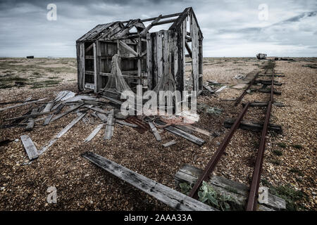 Cabane de pêche vieux abandonnés et rail track sur la plage de galets à Dungeness, Kent, England, UK Banque D'Images