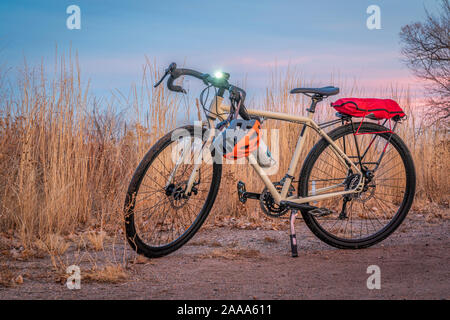 Vélos de cyclotourisme au crépuscule avec le projecteur ou à la fin de l'automne paysage d'hiver dans le nord du Colorado - un sentier de gravier dans la zone naturelle des étangs Riverbend à Fort Banque D'Images