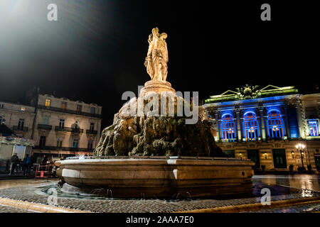 Vue sur la statue des Trois Grâces dans la nuit avec un opéra sur l'arrière-plan dans la ville de Montpellier en France Banque D'Images