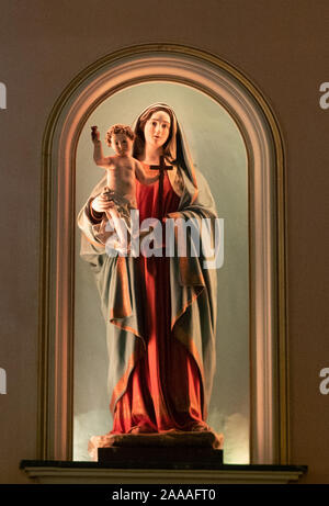 Statue de la Vierge Marie portant l'Enfant Jésus qui tient une croix. La statue est un lit alcôve dans l'Église catholique de Saint Paul dans le Pirée, Grèce. Banque D'Images