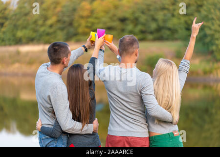 Pique-nique avec des amis au lac près de la tente de camping. Les amis de l'entreprise avoir pique-nique Randonnée nature background. Les randonneurs se détendre pendant le temps de boire. Summer picn Banque D'Images