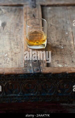 Avec verre de whisky single malt moirée d'or sur une vieille table en bois, utilisé minable d'en haut Banque D'Images