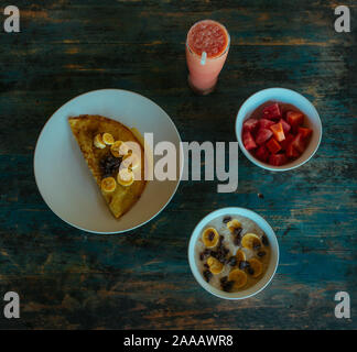 Délicieuses crêpes sucrées avec miel et banane sur une plaque d'argile Banque D'Images