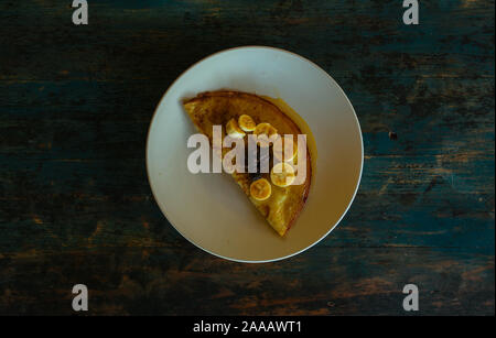 Délicieuses crêpes sucrées avec miel et banane sur une plaque d'argile Banque D'Images