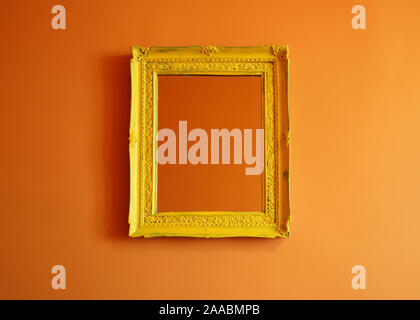 Ancien cadre photo jaune vide isolé sur un mur de couleur orange Banque D'Images