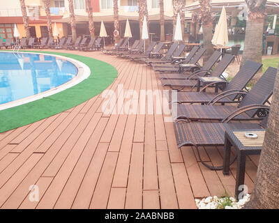 Piscine, transats et parasols pliés sous le soleil de matin d'été. Banque D'Images