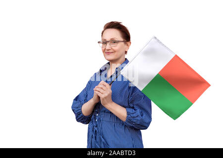 Drapeau de Madagascar. Femme tenant un drapeau de Madagascar. Beau portrait de femme d'âge moyen 40 50 ans la tenue d'un grand drapeau isolé sur fond blanc. Banque D'Images