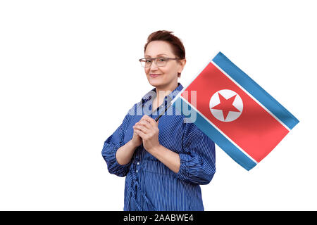 Drapeau de la Corée du Nord. Femme tenant un drapeau de la Corée du Nord. Beau portrait de femme d'âge moyen 40 50 ans la tenue d'un grand drapeau isolé sur fond blanc. Banque D'Images