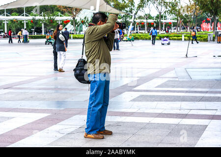 Nantong Ville / Chine - 3 octobre 2011 : Un homme asiatique photographe prendre des photos avec votre appareil photo reflex numérique dans la ville Banque D'Images