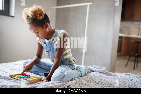 Happy african american girl pour enfants apprendre à compter à la maison avec abacus Banque D'Images