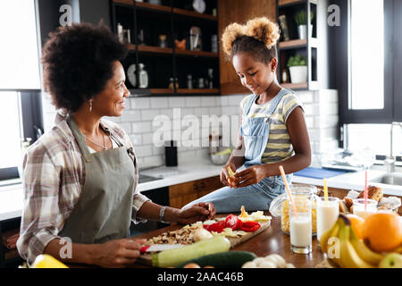 La mère et l'enfant s'amusant de la préparation des aliments dans la cuisine Banque D'Images