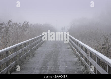 Prendre une marche sur le pont lors d'une froide et glacée matin brumeux aux Pays-Bas Banque D'Images