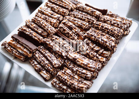 Biscuit, arrosé avec du chocolat blanc, posé sur une plaque carrée. Banque D'Images