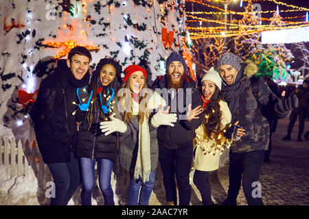 Un groupe de personnes s'amusant à la nuit de Noël. Banque D'Images