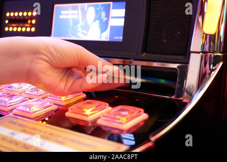 Coquitlam, BC, Canada - 31 mai 2019 : Motion de femme insère de l'argent sur l'intérieur de machine à sous Casino Banque D'Images