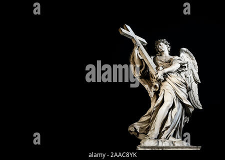 Ange avec la croix statue, sculpture sur le pont Saint Ange (Ponte Sant'Angelo) la nuit, sur fond noir. Copier l'espace. Rome, Italie, Europe UE Banque D'Images