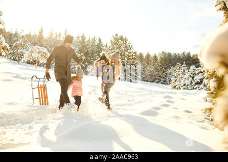 Playful couple avec enfants en hiver woods Banque D'Images