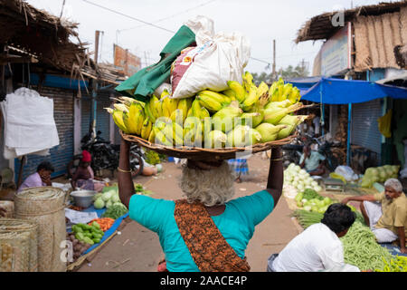 Vieille Femme portant un panier de fruits à vendre sur sa tête au marché en plein air, Tiruchirappalli Tamil Nadu, Inde Banque D'Images