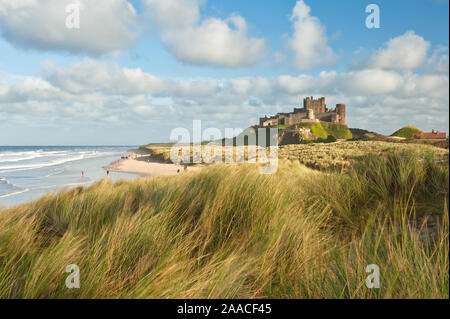 Château de Bamburgh haut perchées sur des rochers escarpés surplombant les dunes côtières, de la plage et de la mer du Nord. Northumberland, Angleterre Banque D'Images