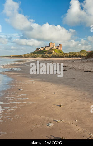 Château de Bamburgh haut perchées sur des rochers escarpés surplombant les dunes côtières, de la plage et de la mer du Nord. Northumberland, Angleterre Banque D'Images