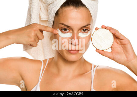 Young woman sous ses yeux sur fond blanc Banque D'Images