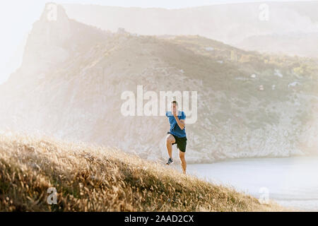 En amont d'exécution runner mâle sunset sea bay Banque D'Images