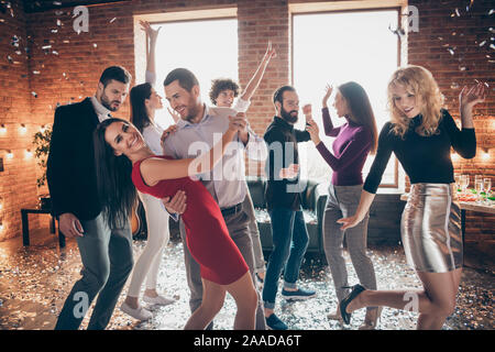 Photo de charme joyeuse de couple positif deux personnes dansant valse entouré par leurs semblables en relevant les confettis Banque D'Images