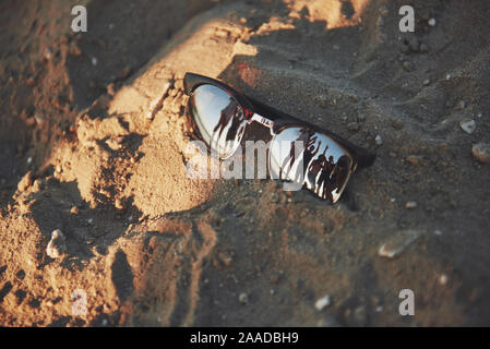 Lunettes de soleil reflétant sur une plage de sable à l'été Banque D'Images