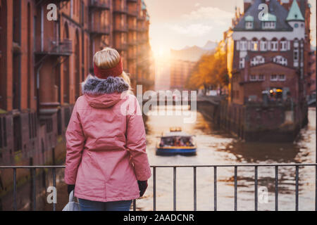 Femme adultes bénéficiant d'golden sunset situé au-dessus de l'Elbe avec plaisir. Historique Speicherstadt warehouse district de Hambourg, Banque D'Images