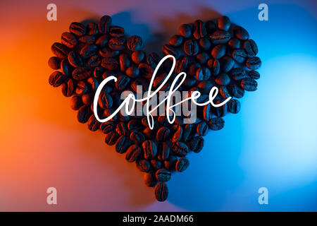 Les grains de café sont mis en évidence par des néons colorés bordée en forme de cœur Banque D'Images