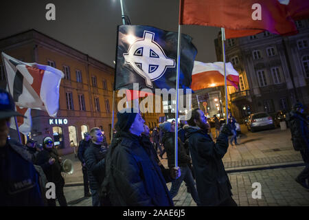 Varsovie, Mazowieckie, Pologne. 20 Nov, 2019. Les étudiants nationalistes qui agitait un drapeau avec la croix celtique qui est le symbole nazi de la suprématie blanche dans le monde pendant la manifestation.Anti-Fascists étudiants et des militants de l'Université de Varsovie réunis sous le slogan ici nous apprendre, nous ne viennent pas (un geste nazi Hitler de vœux), bloquant les portes du campus d'un groupe de nationalistes, qui voulait organiser un soi-disant gauchistes de protestation des élèves immigrants et l'endoctrinement des élèves LGBTQ polonaise par hall. Credit : Attila Husejnow SOPA/Images/ZUMA/Alamy Fil Live News Banque D'Images