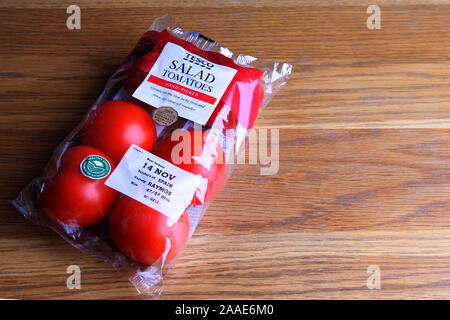 Salade de tomates rouges Tesco Poly plastique scellé wrapper sur table en bois Banque D'Images