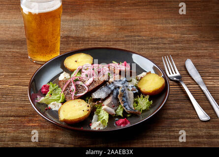 Le maquereau grillé avec des pommes de terre au poisson sur table en bois Banque D'Images