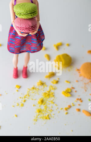 Résumé L'alimentation faite de poupée avec macaron multicolores cookies dessert. Banque D'Images