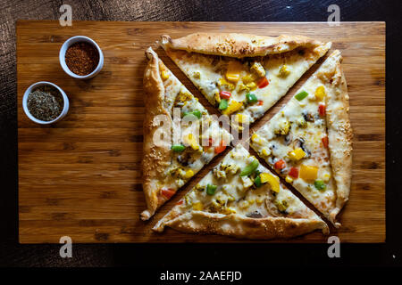 Une pizza avec des herbes colorées sur un plateau en bois - Vue de dessus Banque D'Images