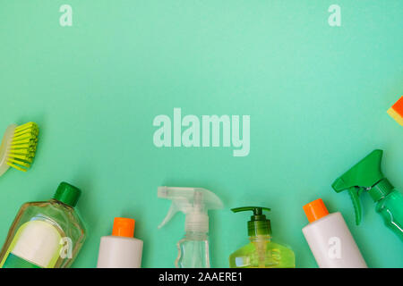 Produits de nettoyage ménagers sur fond vert. En bouteille plastique de détergent, d'éponges et de broussailles. Concept de service. Vue d'en haut. Copier l'espace. Banque D'Images